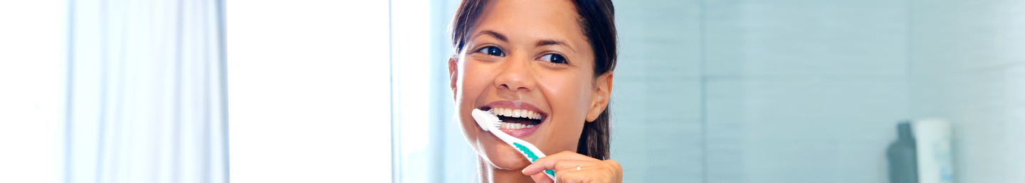 Close-up of a young White woman brushing her teeth in the bathroom